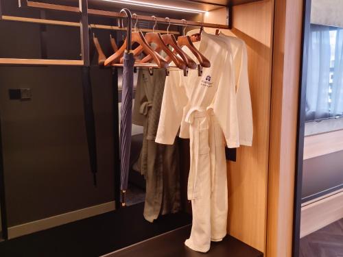 a closet with white clothes and a door at Hotel Royal Signature in Kuala Lumpur