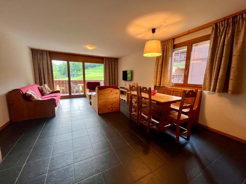 瓦尔·蒂利兹Aparthotel Mountain River Resort的一间带桌椅的客厅和一间用餐室