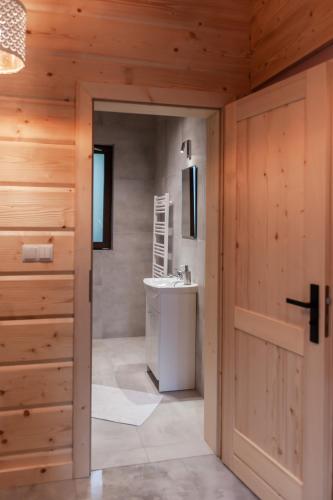 a bathroom with a sink and a toilet and a door at Beskidzkie Wyspy in Tenczyn