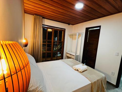 a bedroom with a bed with a towel on it at Duplex Villas Areias do Patacho - Praia do Patacho - Porto Pedras in Pôrto de Pedras