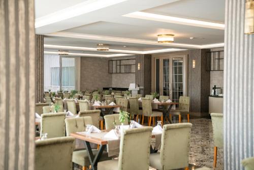 a restaurant with tables and chairs in a room at Hierapark Thermal & SPA Hotel in Pamukkale