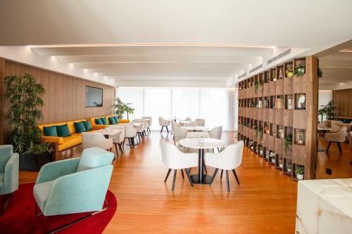a restaurant with tables and chairs in a room at Valentina Residence by GuimaGold in Guimarães