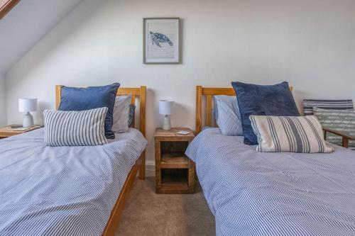 due letti uno accanto all'altro in una camera da letto di Seafront Apartment Hunstanton - Crabpot Cottages a Hunstanton