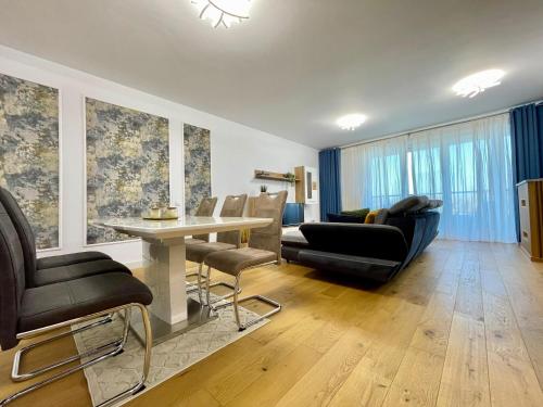 a living room with a couch and a table and chairs at Apartment No 506 Lebada Lake in Pantelimon