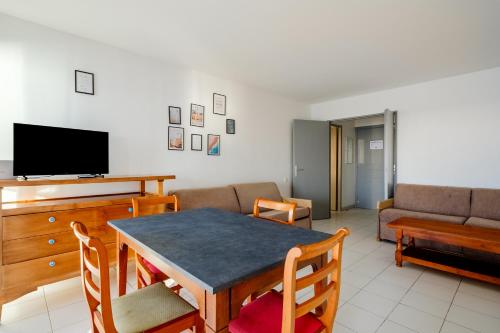 a living room with a table and a couch at Residhotel Villa Maupassant in Cannes