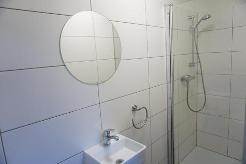 a bathroom with a shower and a sink and a mirror at Kustverhuur, Vakantiepark Fort Soleil 60 in Breskens