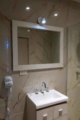 a bathroom with a sink and a mirror at HOTEL CITY in Posadas