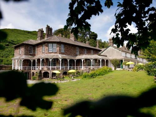 a large brick house with a grass yard at YHA Langdale in Ambleside