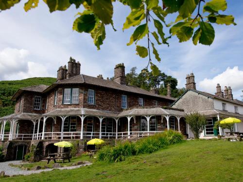 a large brick house with yellow umbrellas in front of it at YHA Langdale in Ambleside