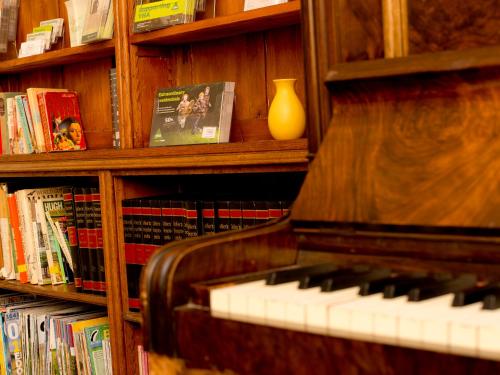 a book shelf with a piano in a library at YHA Langdale in Ambleside