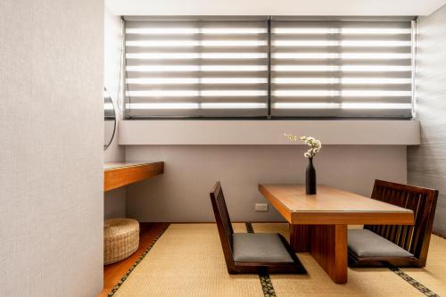 a dining room with a table and chairs and a window at suye hotel in Taichung