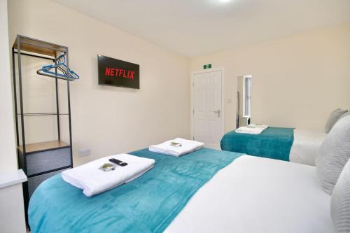 a bedroom with two beds with towels on them at Cosy 1Bed Flat with Garden, Parking & Free Netflix in Coventry