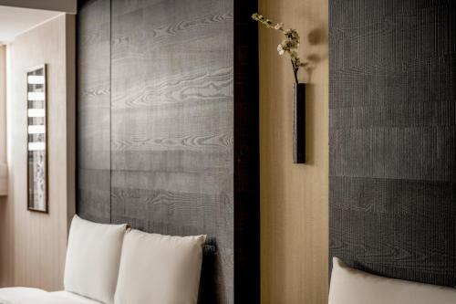 a room with a bed and a vase with flowers at suye hotel in Taichung
