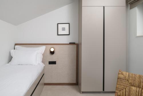 a bedroom with a bed with a light on the wall at Molum Hotel & Residences in Sveti Filip i Jakov