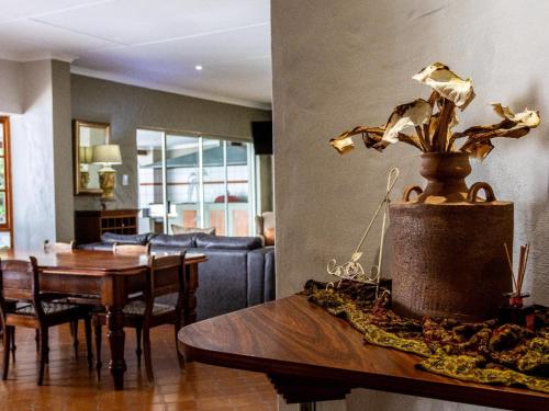 a living room with a table and a dining room at Fairway Lodge in Pongola