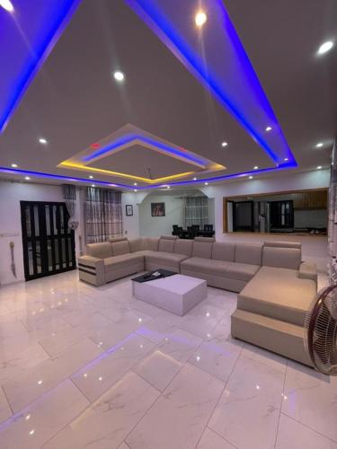 a large living room with couches and a blue ceiling at Tkj in Adidomé
