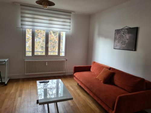 un salon avec un canapé et une table en verre dans l'établissement Tete d or, à Caluire-et-Cuire