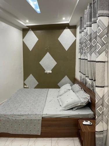 a bedroom with a bed and a wall with triangles at Tkj in Adidomé