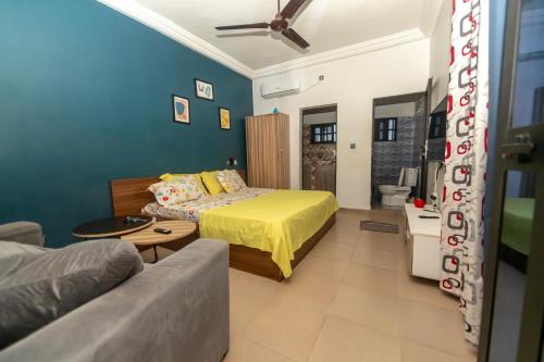 a bedroom with a bed and a living room with a couch at Tkj in Adidomé