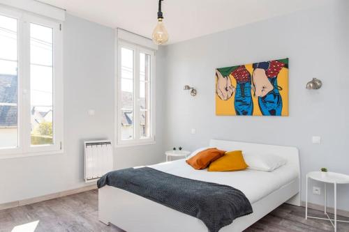 une chambre blanche avec un lit et un tableau au mur dans l'établissement Beau duplex, proche zénith et palais des sports, à Caen