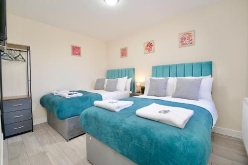 two beds in a room with blue and white at Kings Rest Villa - Free Parking & Netflix, WiFi, Walk to Coventry City Centre in Coventry