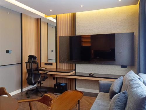 a living room with a couch and a large television at Hotel Royal Signature in Kuala Lumpur