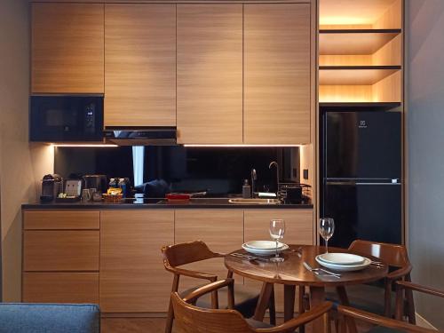 a kitchen with a table and chairs and a refrigerator at Hotel Royal Signature in Kuala Lumpur