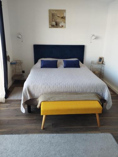 - une chambre avec un lit king-size et une tête de lit bleue dans l'établissement Maison individuelle à Caen, à Caen
