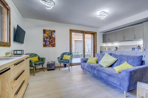 un salon avec un canapé bleu et des chaises dans l'établissement Tanniere des Ours - Snow and Trek, à Morzine