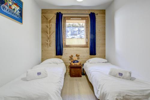 - 2 lits dans une chambre avec un ours en peluche sur une table dans l'établissement Tanniere des Ours - Snow and Trek, à Morzine