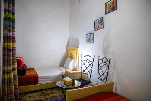a small room with a bed and a table at Dar Fez Arinas in Fès