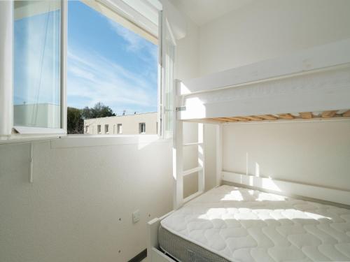 une chambre blanche avec un lit et une fenêtre dans l'établissement LA DUNE 55 - Villa 3P6, à Sérignan