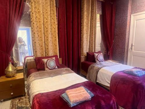 a bedroom with two beds and a chair and a window at Amenti House - Private Villa & Retreat Center in Luxor