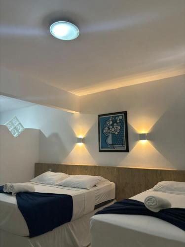 two beds in a room with lights on the wall at Praia Hotel Enseada in Maceió