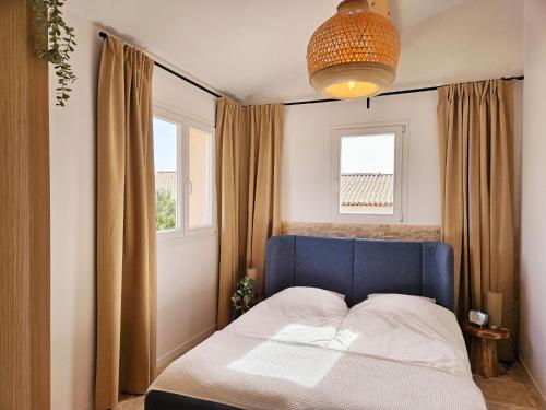 普朗德拉图尔Bambou的一间卧室设有蓝色的床和2个窗户。