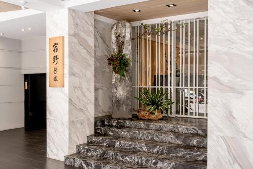 a lobby with stairs with a gate and plants at suye hotel in Taichung