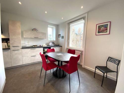 une cuisine et une salle à manger avec une table et des chaises rouges dans l'établissement Maison bretonne rénovée, proche mer, plage et commerces à Trégastel, avec jardin clos et WIFI - FR-1-368-6, à Trégastel