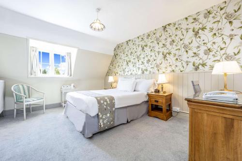 a hotel room with a bed and a desk and a window at Leigh Park Country House Hotel & Vineyard, BW Signature Collection in Bradford on Avon