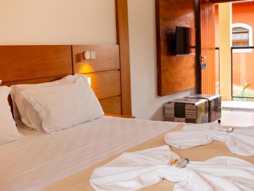 a bedroom with a bed with two towels on it at Pousada Ilha Vitoria in Ubatuba