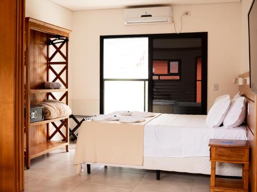 a bedroom with a bed and a large window at Pousada Ilha Vitoria in Ubatuba