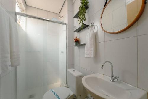 a bathroom with a toilet and a sink and a mirror at Lindo e Confortável Espaço - MEL509 in Maringá