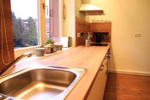 a kitchen with a sink and a wooden counter top at Villa Kolck in Xanten