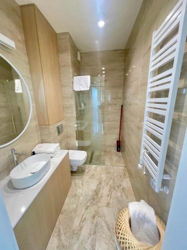 a bathroom with a sink and a toilet and a mirror at Wave Family Apartment E997 - Resort & SPA - SEA VIEW in Międzyzdroje