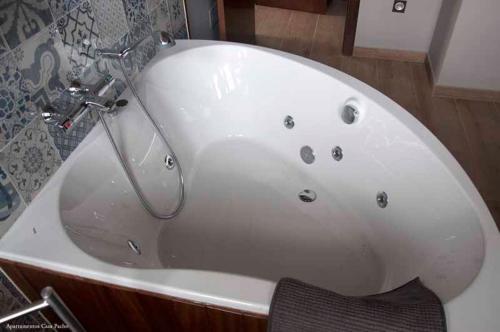 a white bath tub with a chair in a bathroom at Casa Pacho Apartamentos Rurales in Luarca