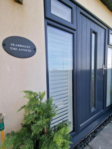 a blue door with a tree in front of it at Seabreeze The Annexe in Blackpool
