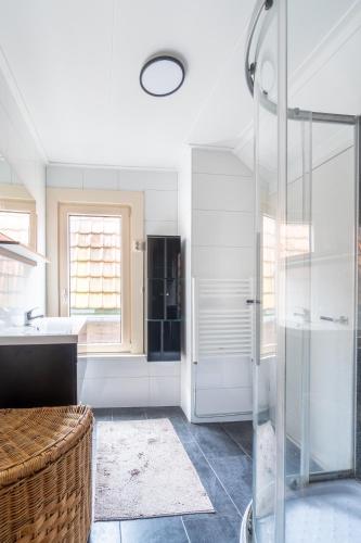 a bathroom with a glass shower and a sink at Logement Old Boorn in Borne