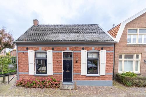 a red brick house with a black door at Logement Old Boorn in Borne