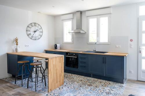 une cuisine avec des placards bleus et un comptoir avec des tabourets dans l'établissement Triplex de qualité, quartier calme, à Caen