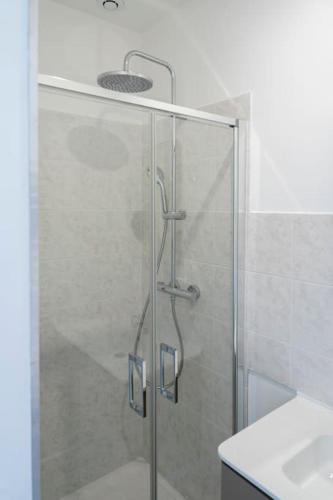 une douche avec une porte vitrée dans une salle de bain dans l'établissement Triplex de qualité, quartier calme, à Caen