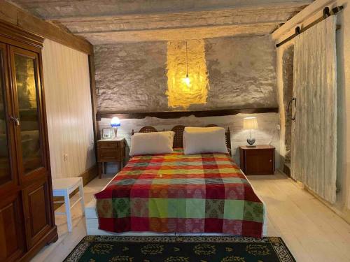 - une chambre avec un lit et une couverture colorée dans l'établissement Maison de charme sur le Canal de Loire, à Bannay